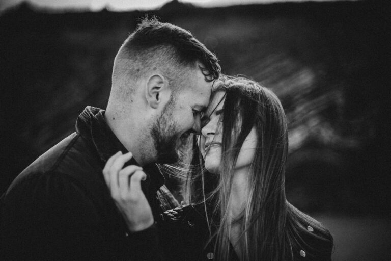 Paul and Ruth during their engagement session on a beach in Cork, Ireland, captured by a professional photographer, with stunning cliffs and ocean in the background.
